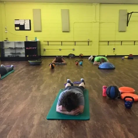 Taking a recovery pose on yoga mats after a hard workout.